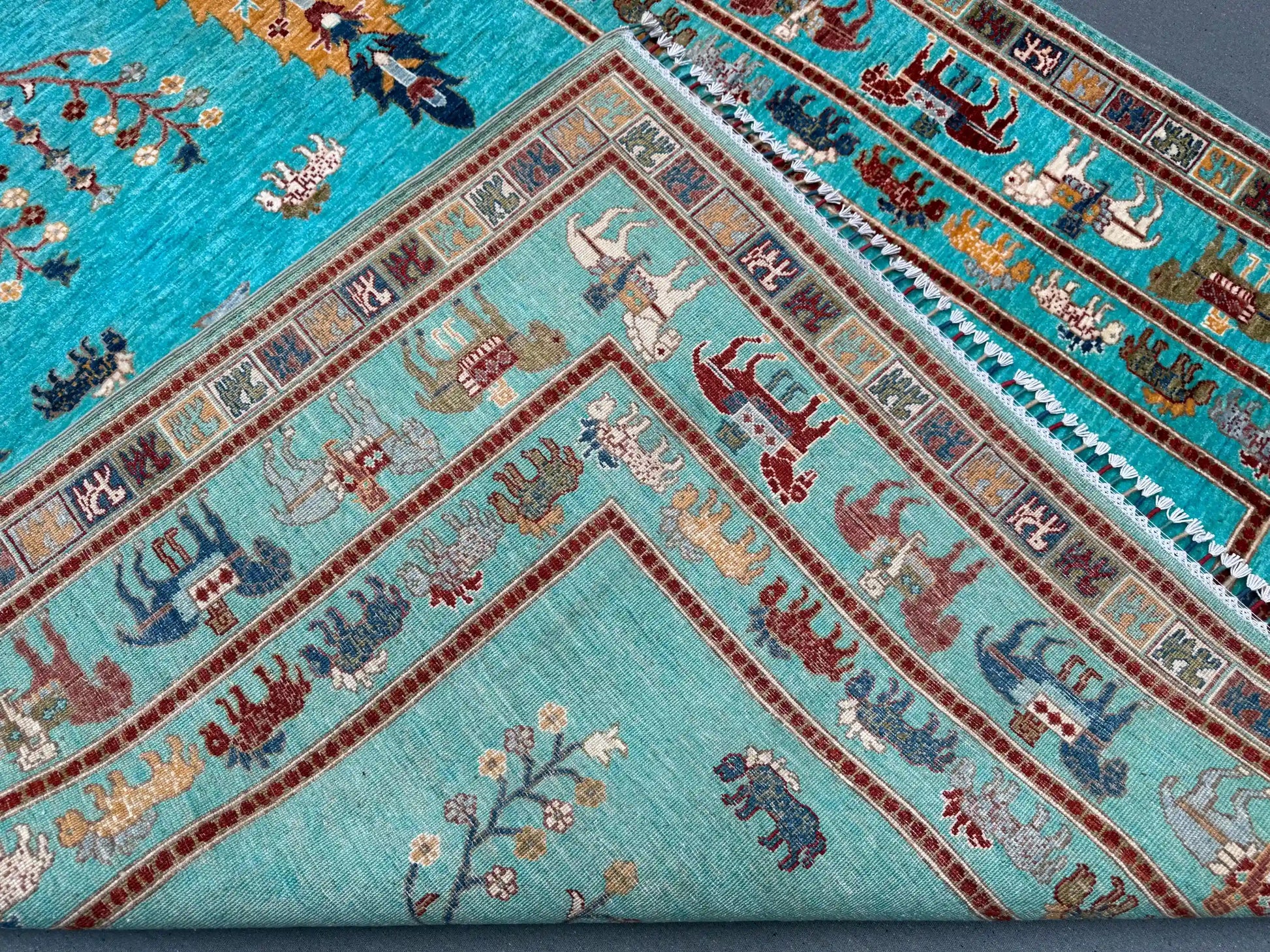 Edge fold detail of Tree of Life handmade turquoise wool rug