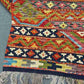 Folded 8x11 Khorjin Kilim rug – vibrant multicolor wool flatweave with tribal design.