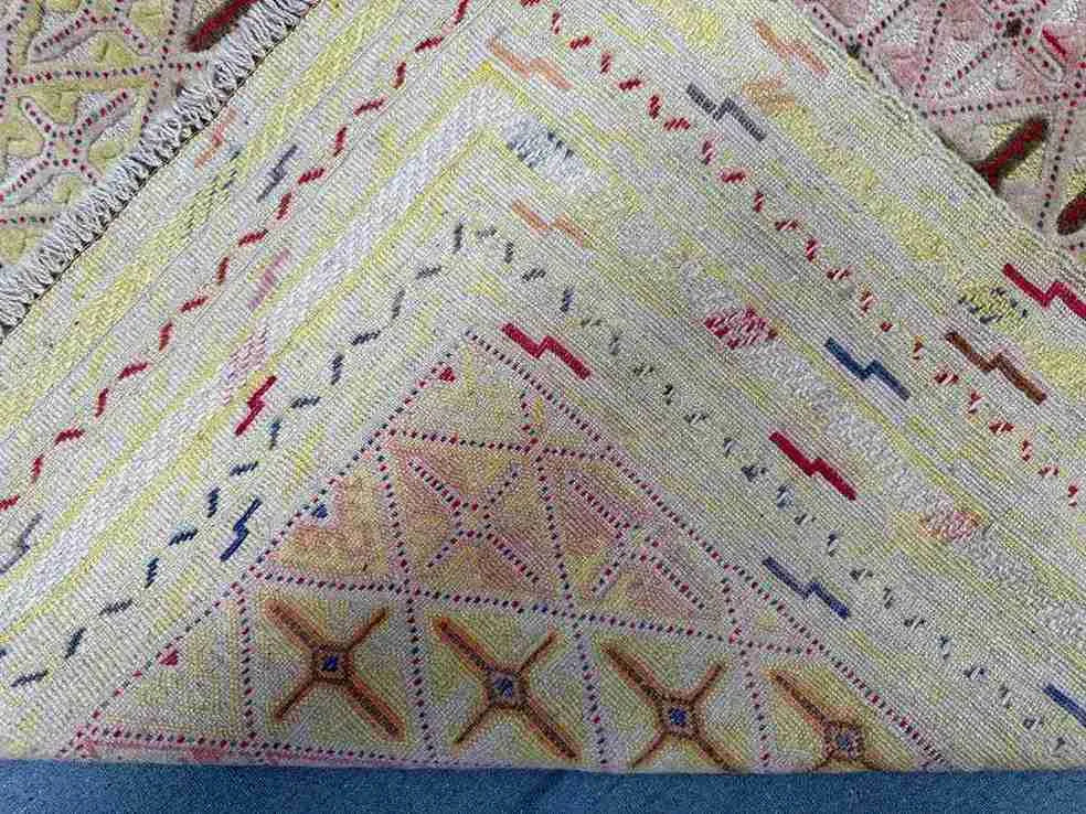Folded view of pastel Afghan kilim showing soft wool craftsmanship