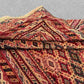 Side view of folded Persian Afghan rug showing wool thickness