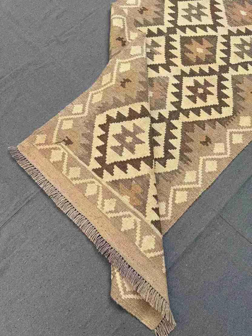 Folded view of flatweave Kilim runner rug in beige and brown – easy to store and reversible.