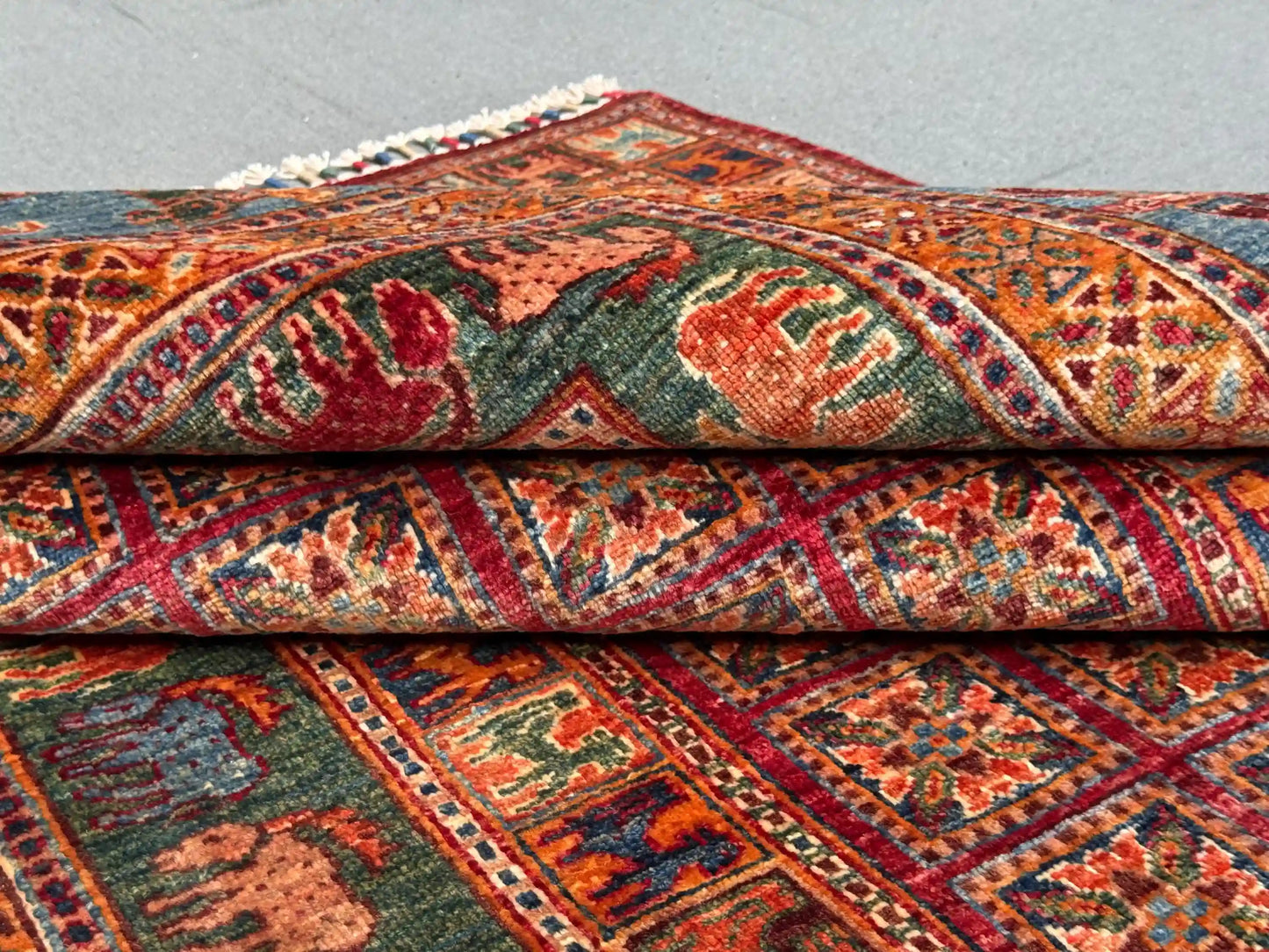 Folded 6x8 handmade Pazyryk wool rug in red and blue tones