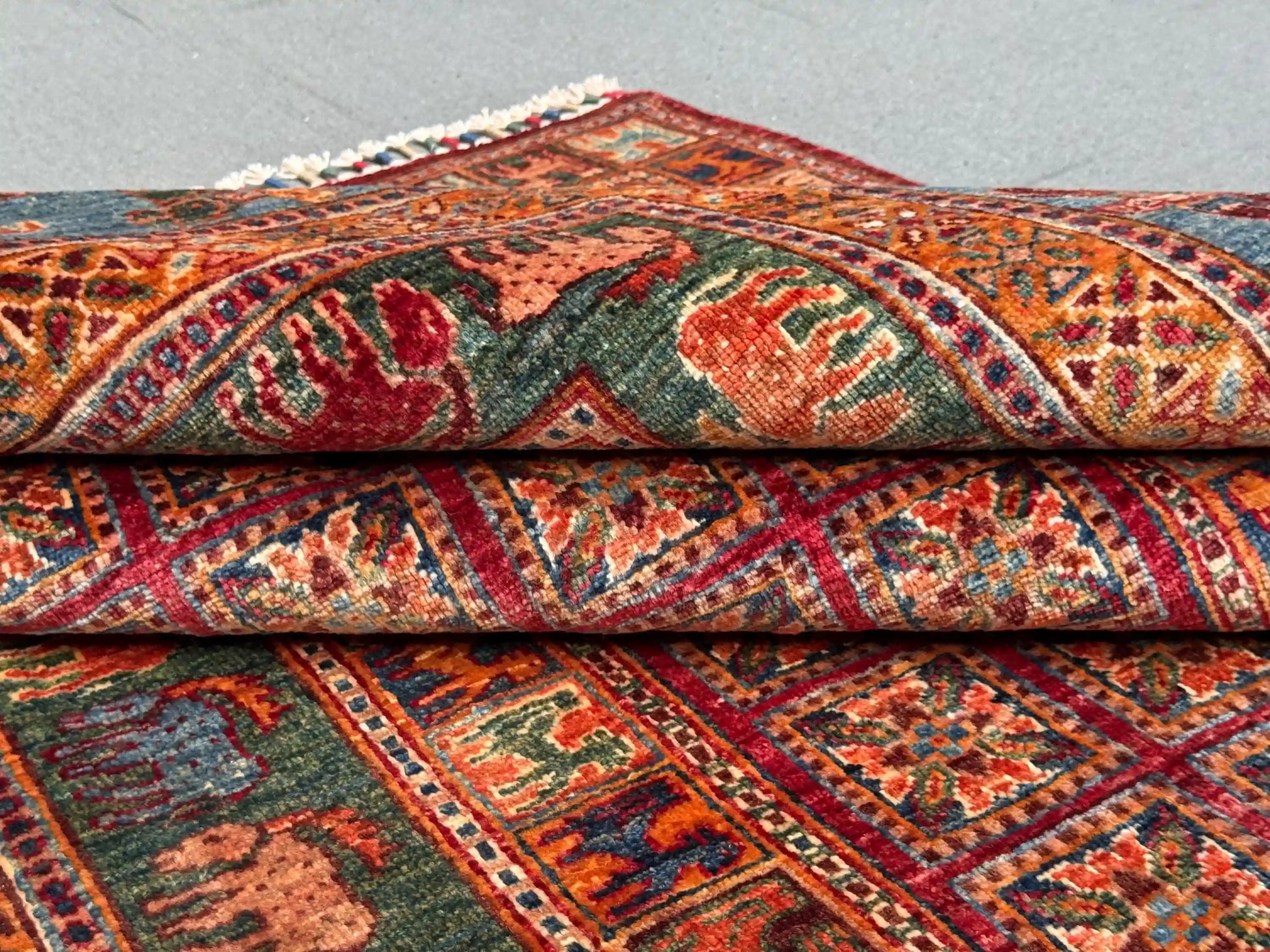 Folded 6x8 handmade Pazyryk wool rug in red and blue tones