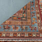 Folded 6x8 handmade Pazyryk wool carpet in red and blue tones