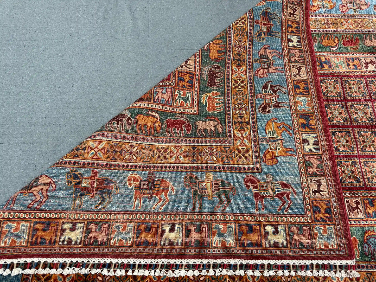 Folded 6x8 handmade Pazyryk wool carpet in red and blue tones
