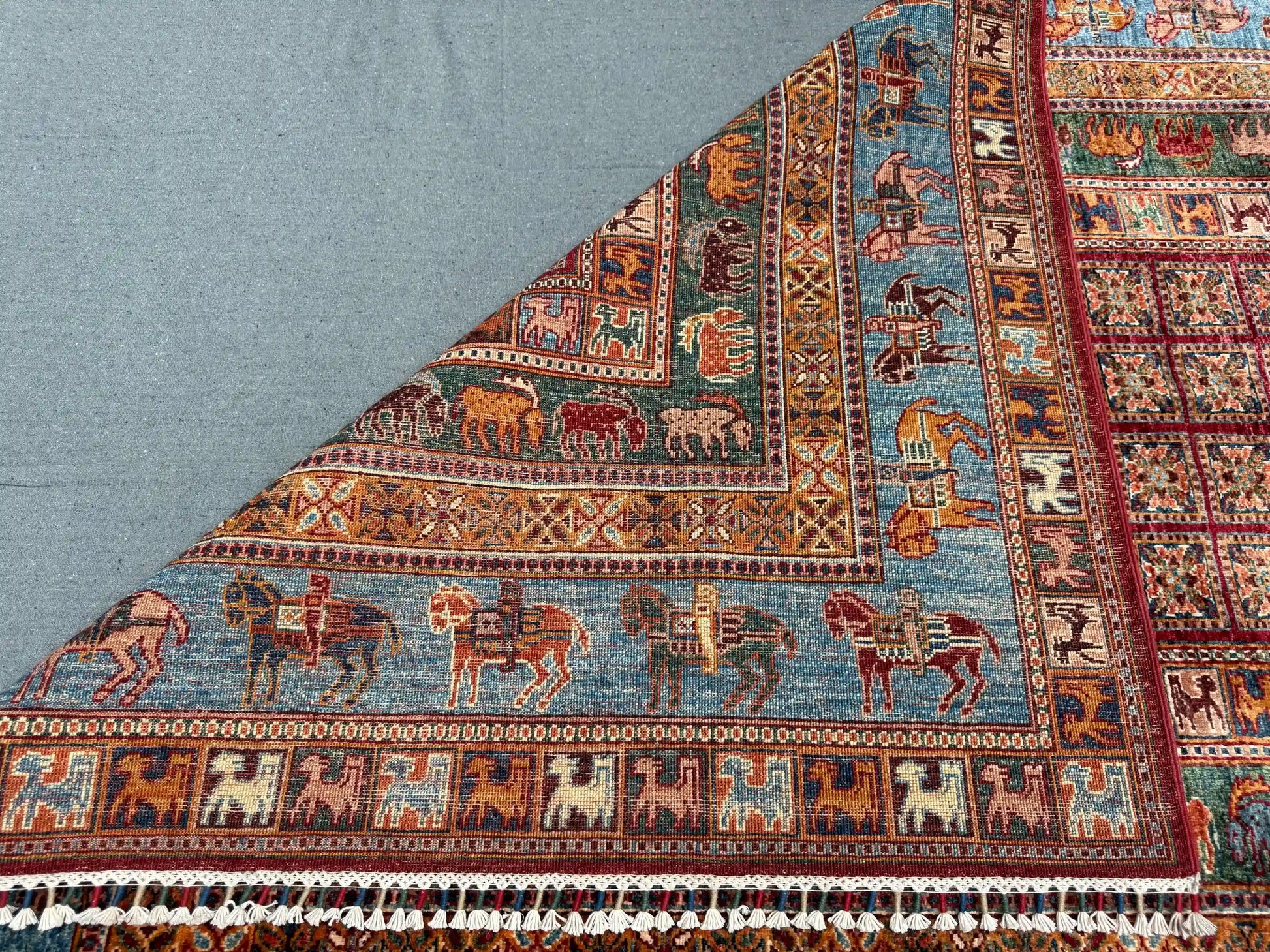 Folded 6x8 handmade Pazyryk wool carpet in red and blue tones