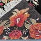 Folded Karabakh rug showing wool texture and floral edge pattern