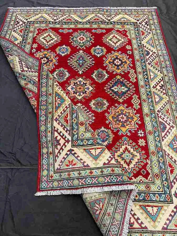 Folded view of handmade 5x7 Kazakh wool rug showcasing texture