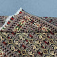 Folded Oriental rug showing wool silk tribal and Persian floral design