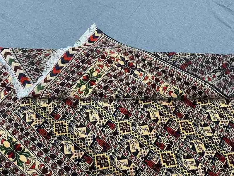 Folded Oriental rug showing wool silk tribal and Persian floral design