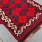 Folded view of small Afghan Kilim rug – handmade red wool flatweave with tribal motifs.