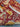 Folded view of red Persian rug with visible bird and tree design