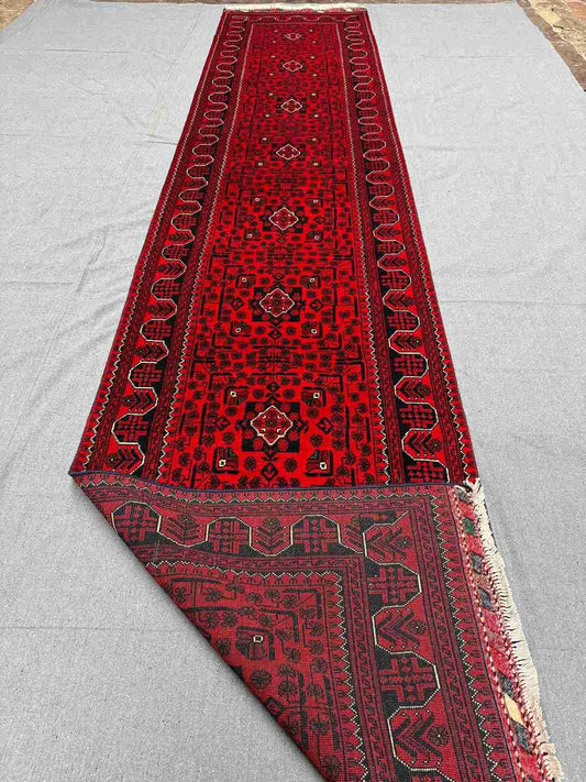 Folded red runner rug showing backside knots and quality Turkish weave