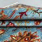  Close-up of folded red and blue Sultani Persian wool rug