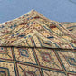 Side view of folded Turkish Afghan kilim rug showing wool edges