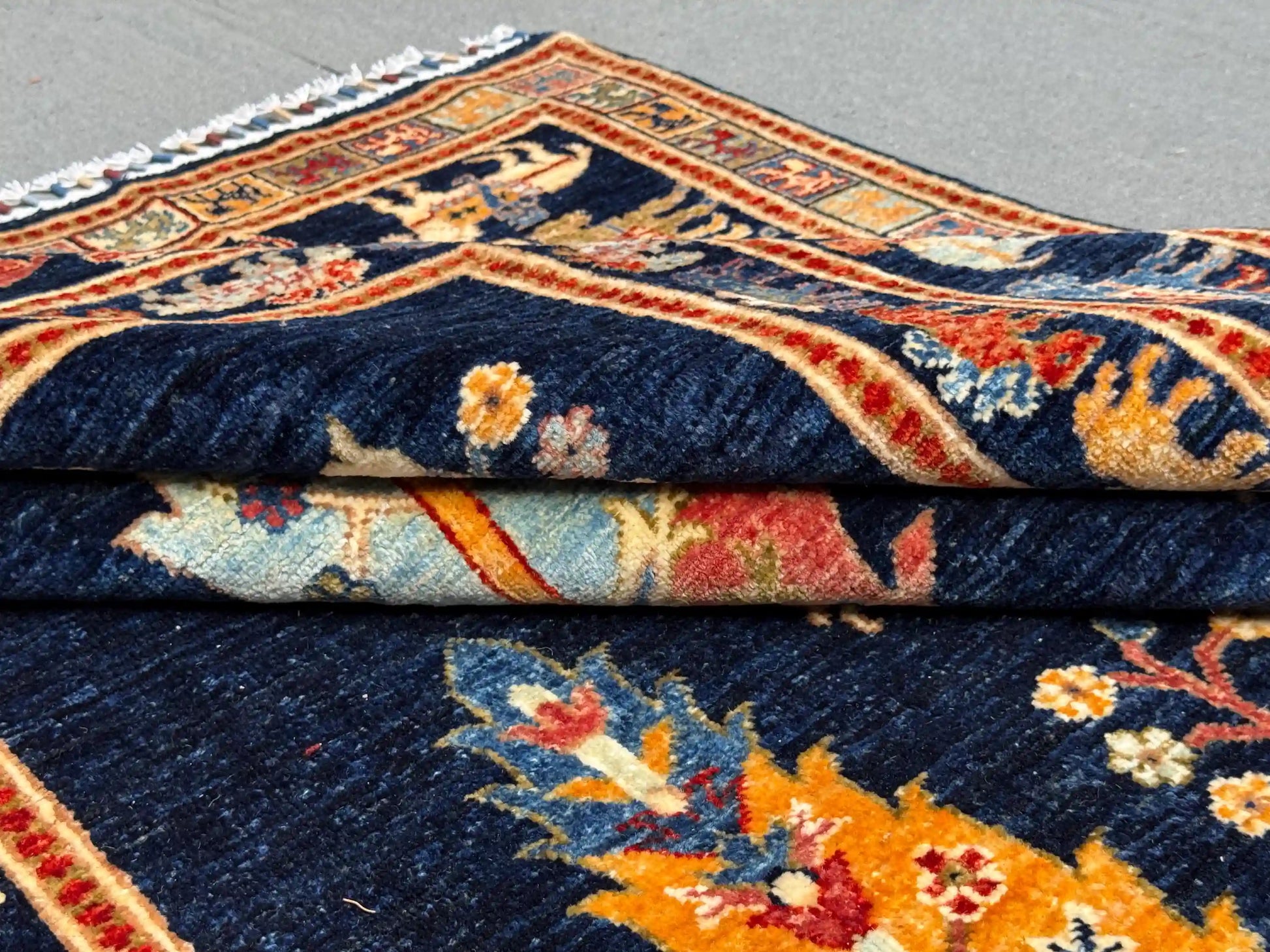 Folded view of Tree of Life rug showing texture and color