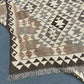 Folded view of wool Kilim rug – 8x10 Turkish handmade piece with earthy and vibrant pattern.