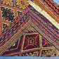 Folded tribal red and gold wool kilim rug with bohemian texture