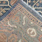 Folded 5x9 blue and beige Persian-style rug showing backside knotting