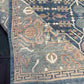 Folded 5x9 blue and beige Persian-style rug showing backside knotting