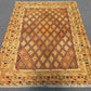 Full layout of 5x6.2 oriental area rug with warm tribal colors placed on the floor