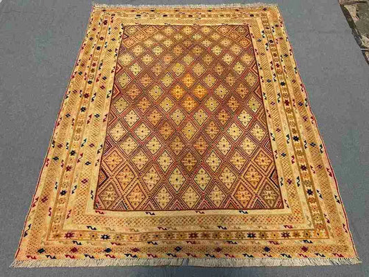 Full layout of 5x6.2 oriental area rug with warm tribal colors placed on the floor