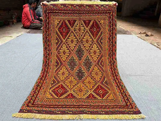 Full top-down view of handmade red and gold Afghan kilim rug