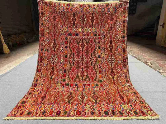 Full top-down view of 4.9x6.6 Turkish Afghan kilim rug with geometric tribal design in red and orange