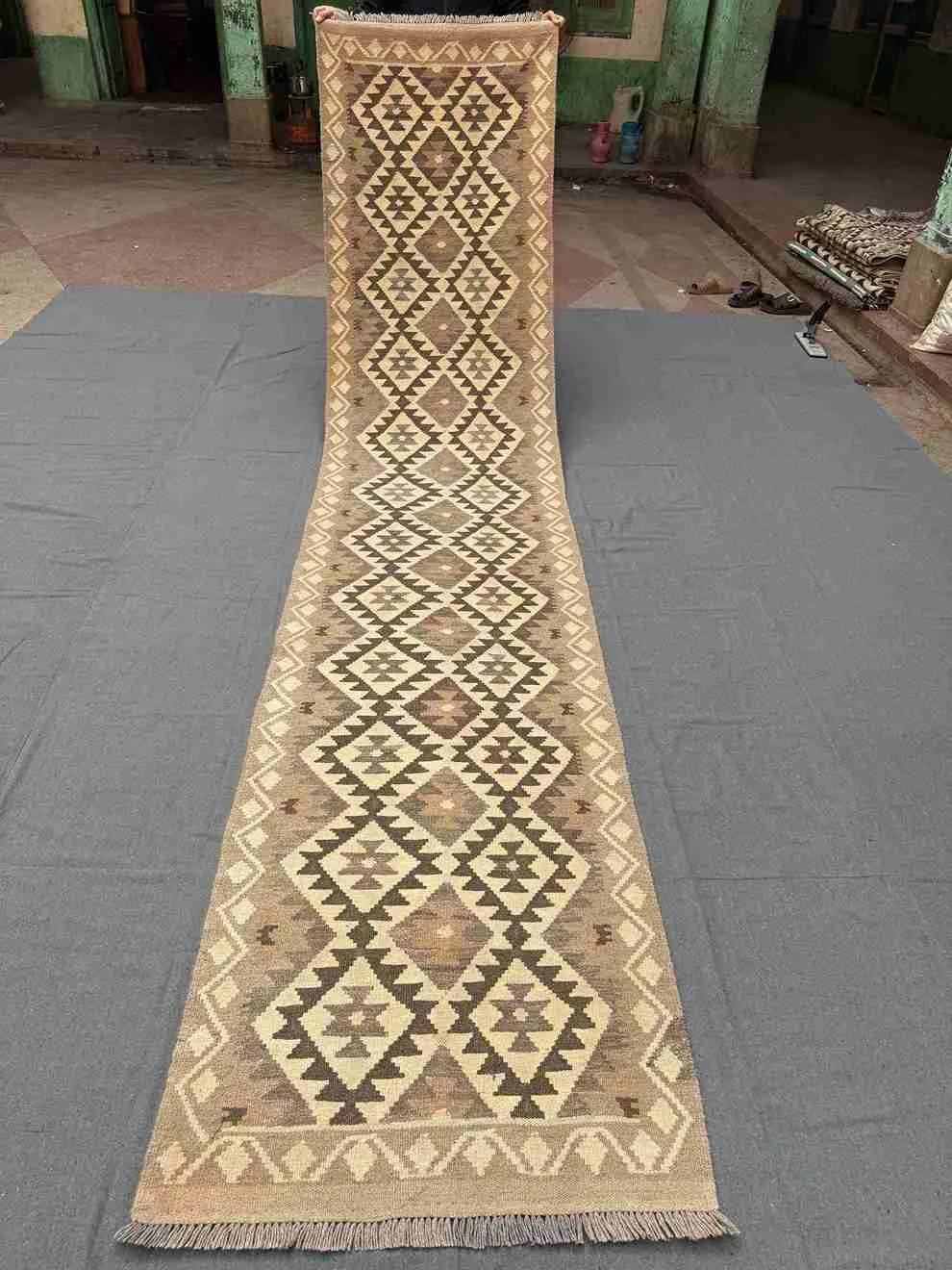 Full view of 13ft long handmade Kilim runner rug – flatweave wool in beige and brown.