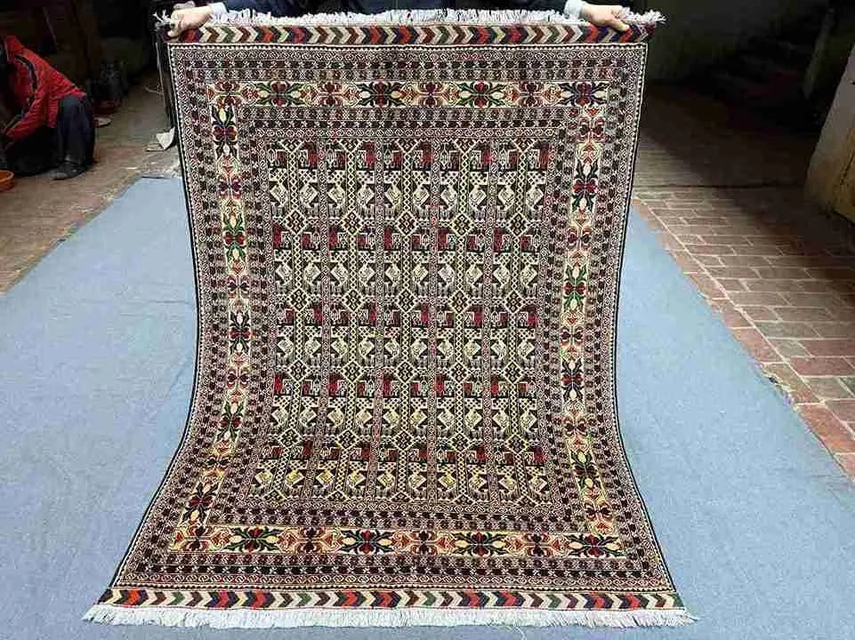 Full top-down view of handmade 5x7 Oriental rug with floral and geometric patterns