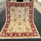 Full top-down view of authentic hand-knotted red and cream 5x7 wool rug