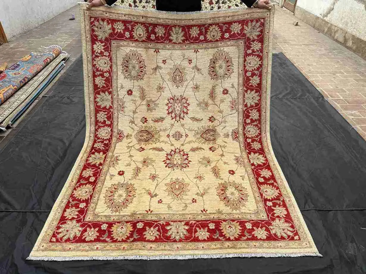 Full top-down view of authentic hand-knotted red and cream 5x7 wool rug