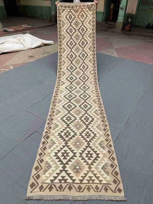 Full view of handmade beige and brown kilim runner rug
