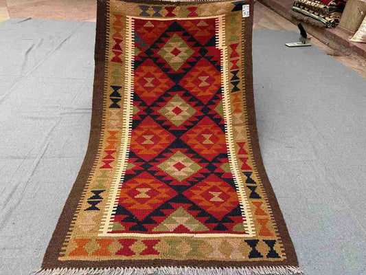 Full view of handmade vintage Turkish Kilim rug – red and brown multicolor wool flatweave with tribal patterns.