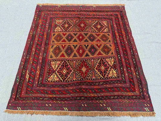 Geometric kilim rug on the floor showcasing tribal patterns