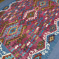  Detailed view of hand-knotted geometric motifs in colorful Kilim rug.
