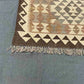 Corner detail of geometric Turkish Kilim rug – wool flatweave with vibrant and neutral color accents.