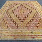Close-up of geometric tribal pattern in pastel Afghan kilim rug