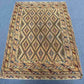 Geometric Afghan tribal rug on floor with red, blue, and beige tonesc