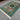 Green and turquoise artisan rug decorating contemporary floor space