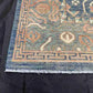 Corner detail of knotted 5x9 wool rug showing floral Persian design