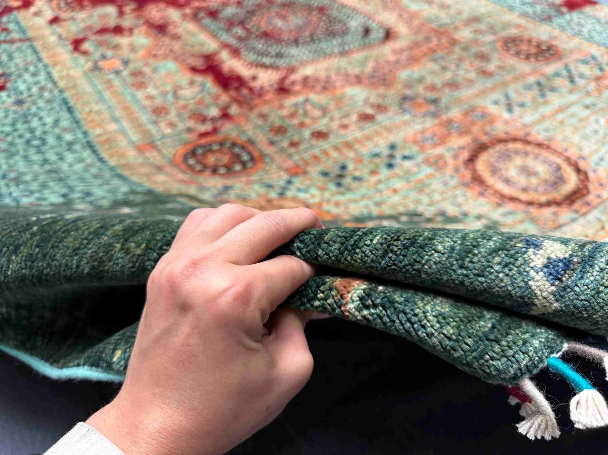 Front view of 6x8 handmade wool & silk Mamluk rug held in hands