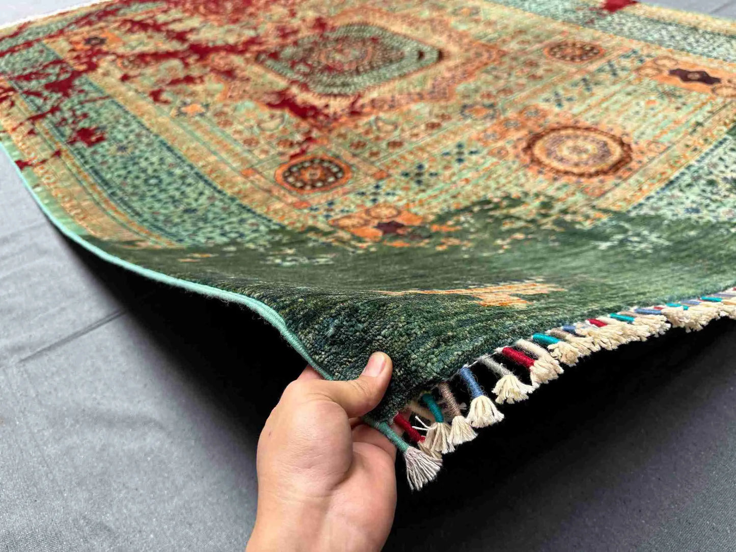 Front view of 6x8 handmade wool & silk Mamluk rug held in hands