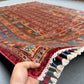 Handmade 6x8 Pazyryk rug held to show softness and weave