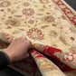 Handmade 5x7 red and cream wool carpet shown in hands – Chobi Persian floral design