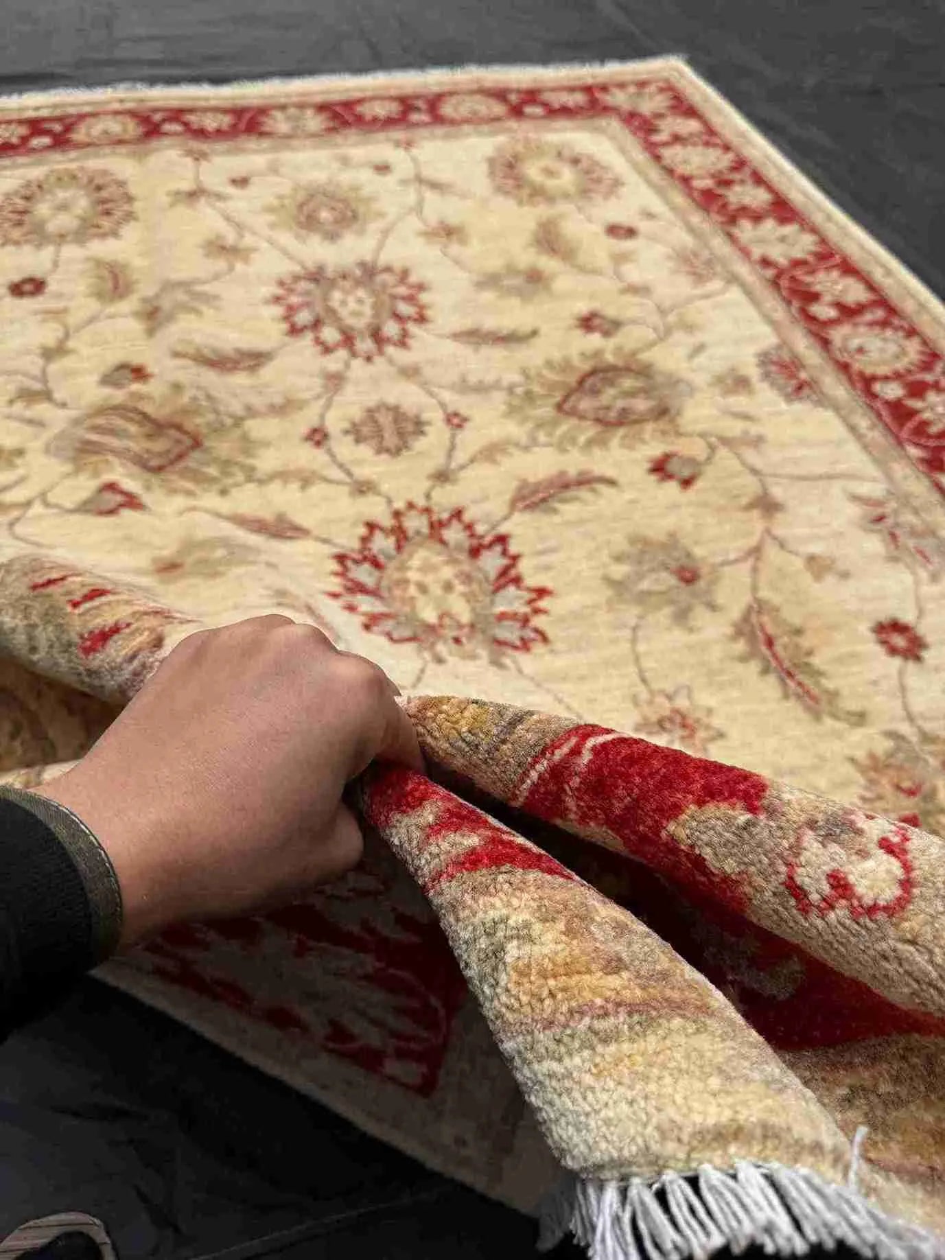 Handmade 5x7 red and cream wool carpet shown in hands – Chobi Persian floral design