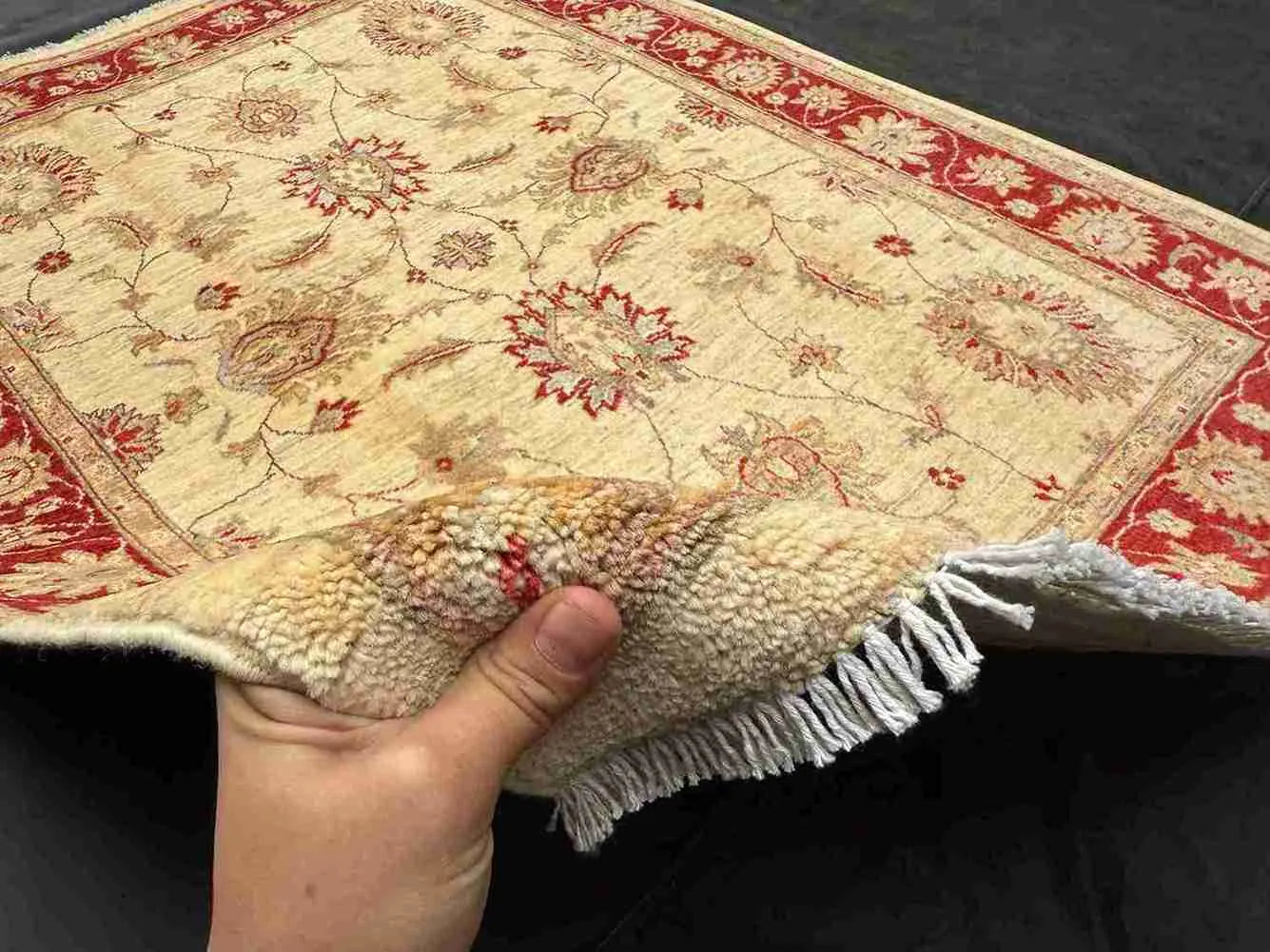 Handmade 5x7 red and cream wool rug shown in hands – Chobi Persian floral design