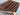 Knotted Persian-inspired tribal rug held in hand – blue and red pattern