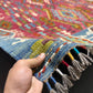 Authentic handmade 5x8 Turkish Kilim rug in hands showing texture and craftsmanship.