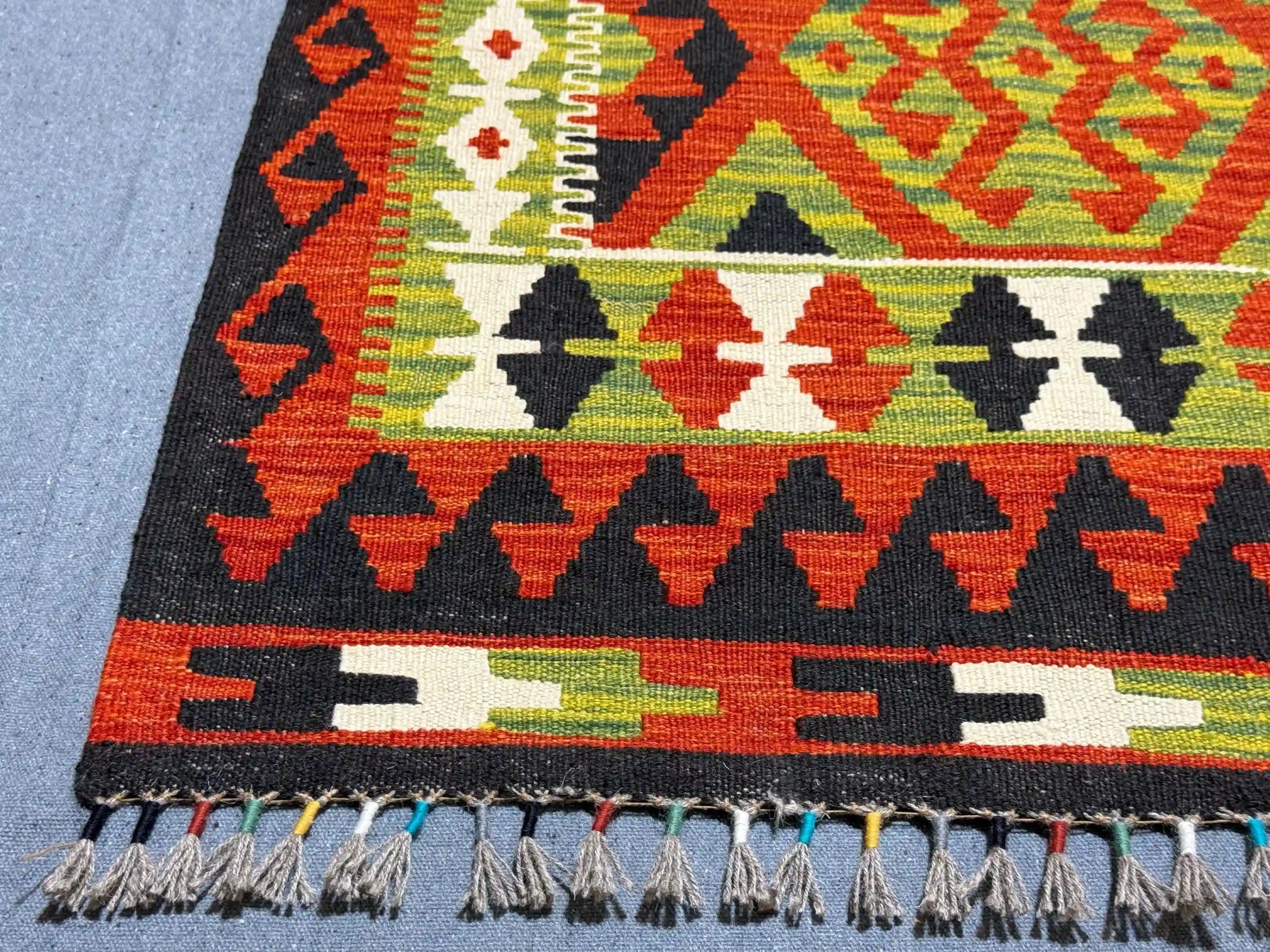 Corner detail showing the tight flatweave of multicolor tribal Kilim rug